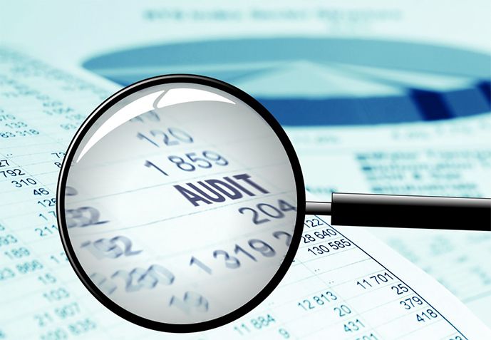 A magnifying glass held over an audit report